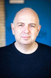 Portrait von Frank Goosen vor blauem Hintergrund